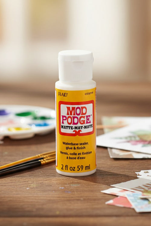 Mod Podge decoupage glue in Pakistan with Ash and Ivory themed use, shown in a container, ideal for DIY crafts, furniture decoration, sealing, and creative decoupage projects.